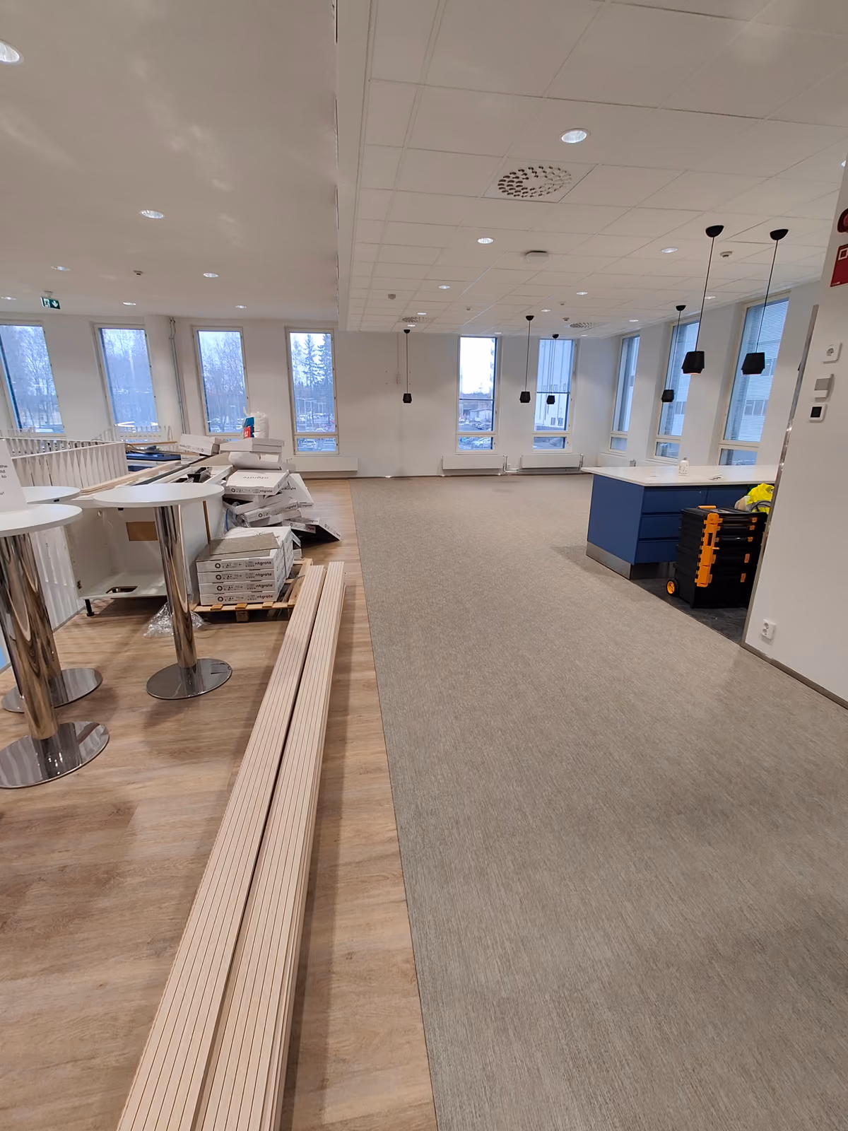 Kontorsutrymme under möblering, material och möbler på golvet